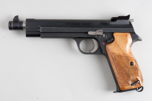 Eine Waffe liegt auf einer weißen Fläche.