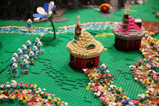 Ein Lego-Modell einer Kleinstadt mit Blumen, Spielzeugen, Häusern, Pflanzen und anderen Gegenständen mit leicht unscharfem Hintergrund.