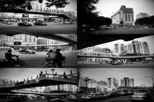 Autos und Fahrräder sind unter einer Brücke zu sehen, mit einigen Fahrzeugen vor einem Gebäude.