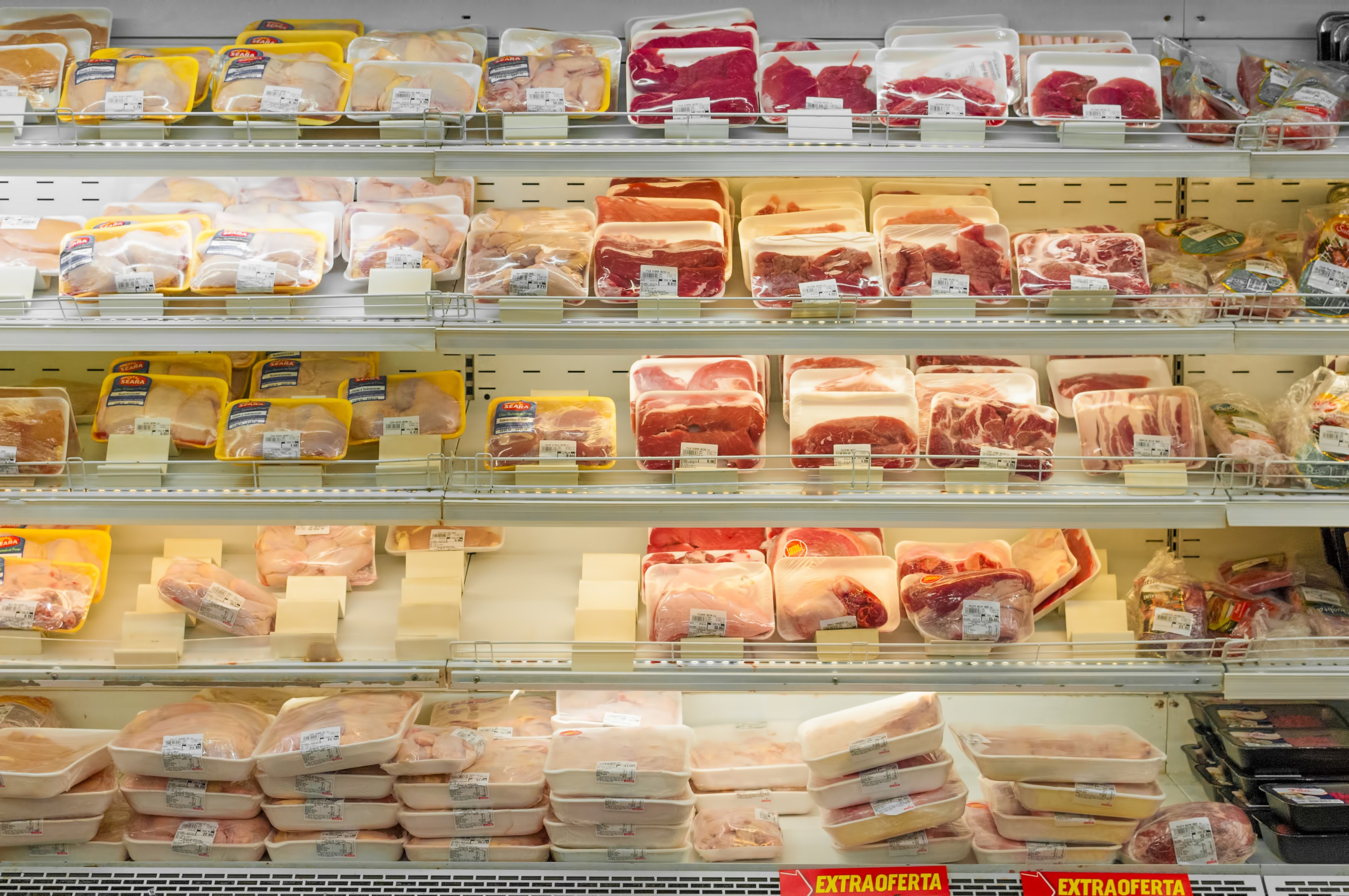 Ein gut organisierter Supermarktboden mit verschiedenen Fleischsorten und daran befestigten Preisschildern.