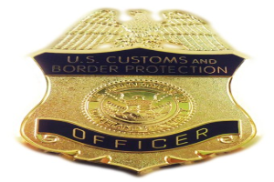 Goldabzeichen mit "U.S. Customs and Border Protection Officer" Text auf einem weißen Hintergrund.