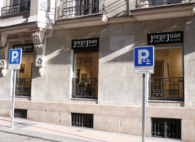 Ein mehrst├Âckiges Geb├Ąude mit Fenstern, Gel├Ąndern, Türen und S├Ąulen, das Schilder an Pfosten entlang des Gehwegs und sichtbare Innenobjekte aufweist, die eine belebte Stadtkulisse vermuten lassen.