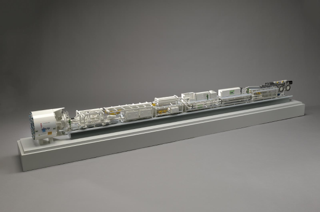 Ein detailliertes Modell eines großen Wasserstoff-Brennstoffzellensystems mit sichtbaren Komponenten, darunter ein Kraftstofftank, ein Filter und ein Injektor, der mit einer Stromquelle auf einer weißen Oberfläche verbunden ist.