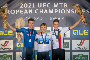 Drei medaillenreiche Radrennfahrer auf einem Podium bei den 2021 UEC MTB Europameisterschaften, jeder hält einen Blumenstrauß.