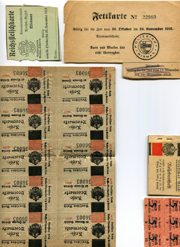 Eine Sammlung alter, abgenutzter deutscher Fahrkarten und Marken mit gedrucktem Text und Zahlen auf einem weißen Hintergrund.