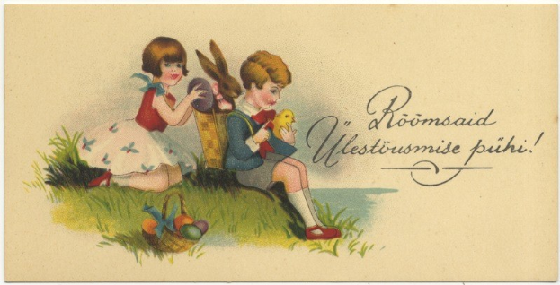 Alte Postkarte mit zwei Kindern auf dem Gras, eines hält einen Korb mit Ostereiern und das andere ein Spielzeug, im Hintergrund ein Plakat mit Text.