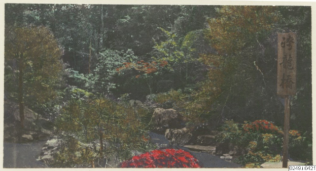 Ein japanischer Garten mit üppigen grünen Bäumen, leuchtenden Pflanzen, verstreuten Steinen und bunten Blumen, mit informativem Text auf einer Tafel und unten.