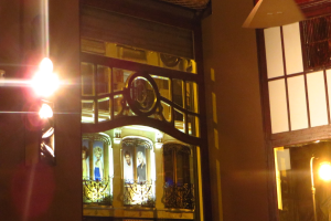 Ein Gebäude mit Grills, Plakaten und Lichtern drumherum.