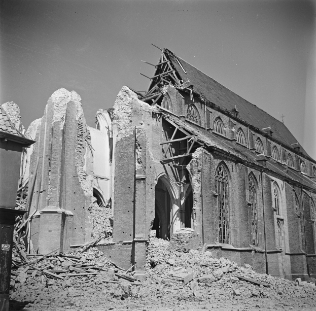 Ein Schwarz-Weiß-Foto einer zerstörten, abgerissenen Kirche mit gebrochenen Wänden und verstreuter Trümmer, unter einem sichtbaren Himmel.