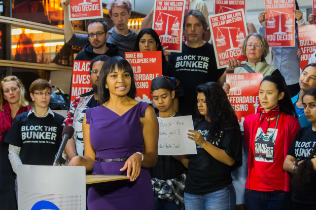 Eine Black-Lives-Matter-Aktivistin, die vor einer Menge mit Schildern spricht.