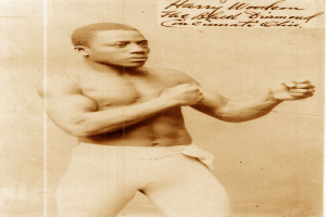 Ein Mann in einem Boxring mit Handschuhen und Shorts, der entschlossen aussieht und aufrecht steht, mit Text über dem Bild.