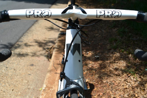 Ein Fahrrad ist in der Mitte des Bildes positioniert, mit einer Straße auf der linken Seite.