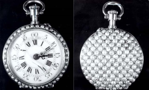 Eine silberne Taschenuhr mit Diamanten, die in ein rundes Zifferblatt mit römischen Zahlen eingelassen sind, auf einem schwarzen Hintergrund.