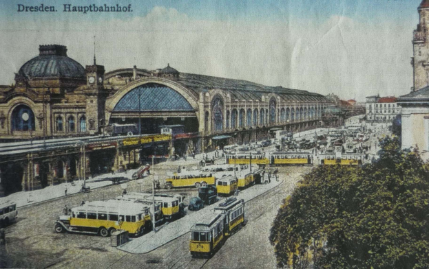 Schwarz-weiß-Postkarte des Dresdner Hauptbahnhof in Deutschland, die eine belebte Straßen Szene mit Fahrzeugen, Fußgängern, Bäumen, Gebäuden und einem bewölkten Himmel zeigt.