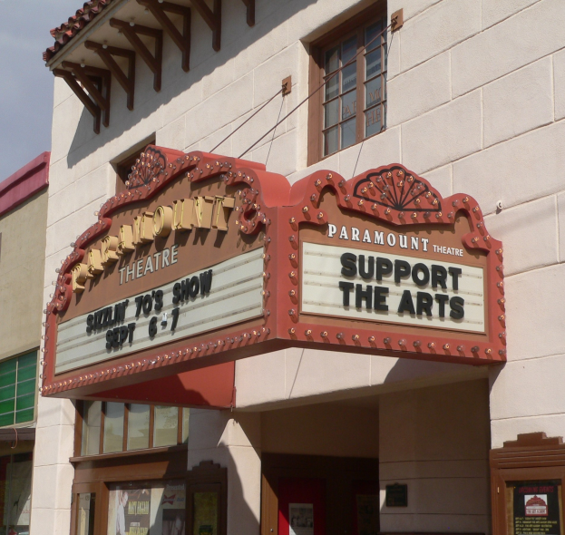 Außenansicht des Paramount Theatre in Sacramento, Kalifornien, mit Glasfenstern und -türen sowie einer 'Support the Arts'-Schrifttafel und einem sichtbaren Himmel im Hintergrund.