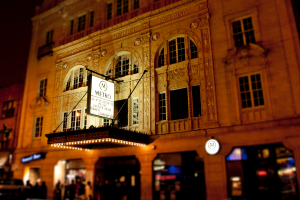 Ein gelbes Gebäude mit Geschäften im Erdgeschoss, von denen eines ein weißes Schild mit der Aufschrift "Metro" trägt.