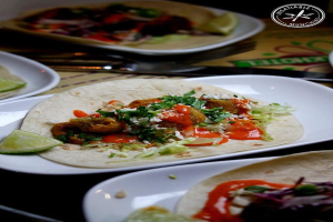 Ein Tisch mit Tellern, einem Messer und einem Logo in der oberen rechten Ecke.
