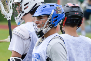 Three players in white jackets and helmets, with a blurred background.